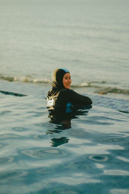 Woman in modest swimwear enjoying infinity pool - modest swimsuit styles that still look chic