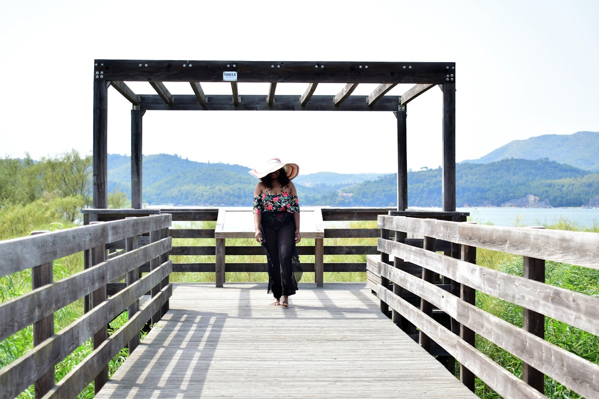 woman wearing swimsuit and sun hat on vacation bridge summer style