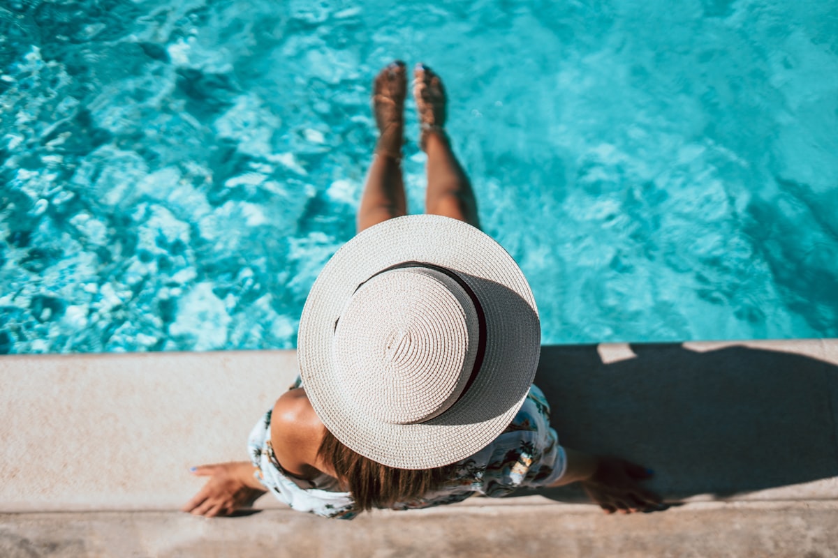 woman relaxing by swimming pool in flattering one-piece swimsuit