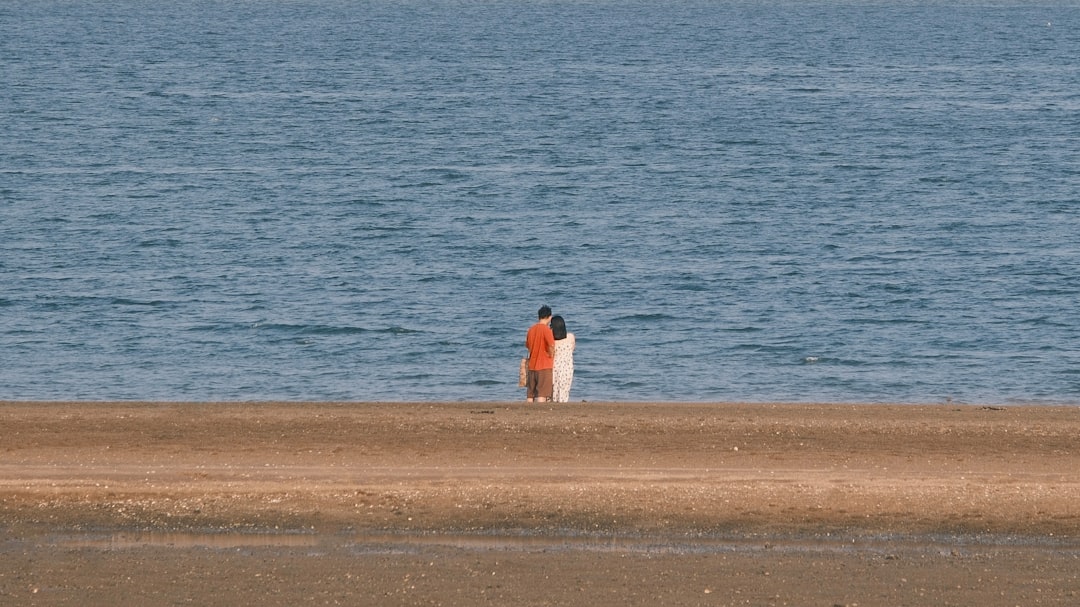 Woman in orange bikini standing confidently on beach showing body positivity