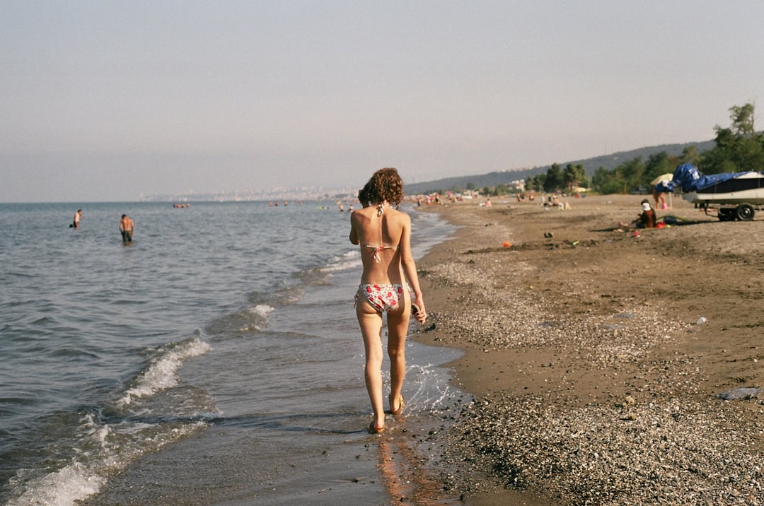 Woman walking confidently on seashore embracing body positive mindset
