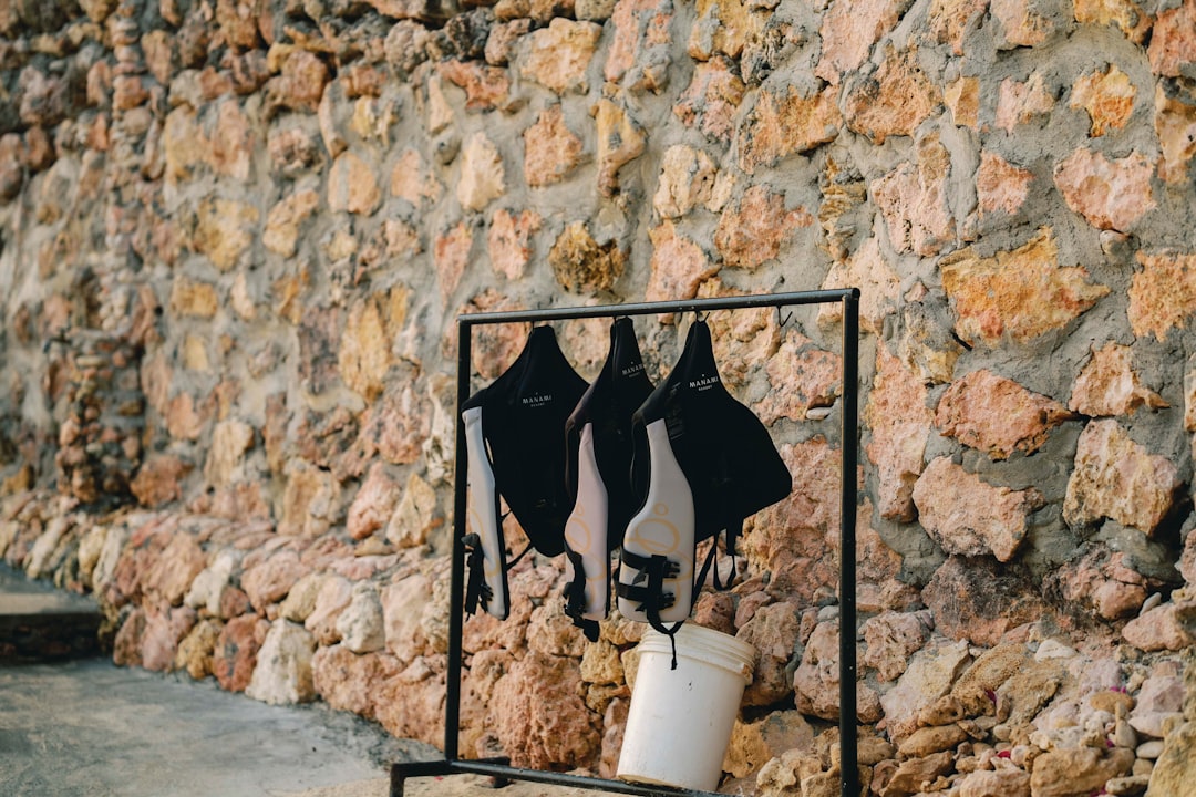 A stone wall with a picture of two women's shirts hanging on it