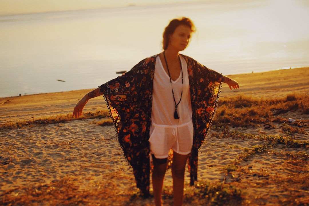 a woman standing on top of a sandy beach