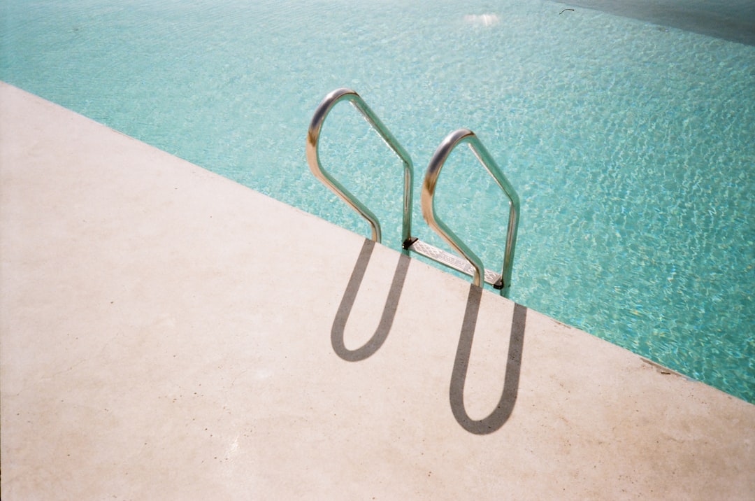 Metal ladder casting shadows into a swimming pool