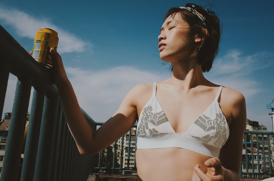 a woman in a bikini holding a can of beer