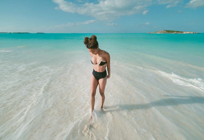 Body-positive black high-waisted bikini bottoms on tropical beach