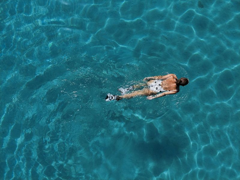tankini swimsuit swimmer doing laps in clear blue water