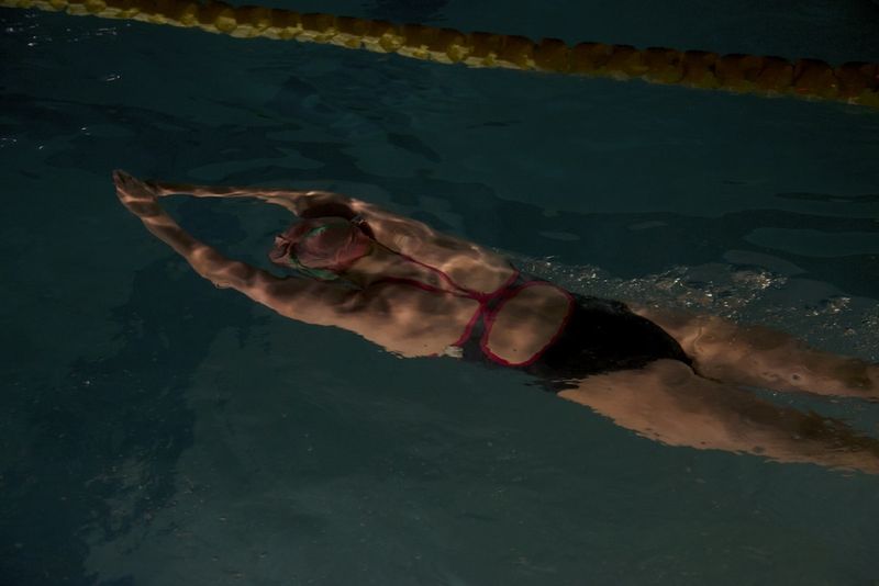 Athletic swimmer in a one-piece swimsuit for an athletic body type doing freestyle