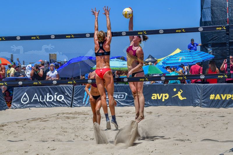 Women playing beach volleyball in athletic swimwear