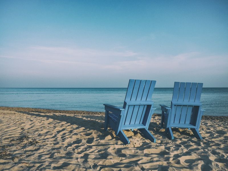 Tankini tops for beach vacation — wooden beach chairs by the water