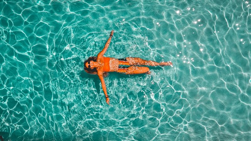 Brazilian bikini bottom poolside, overhead view in clear water