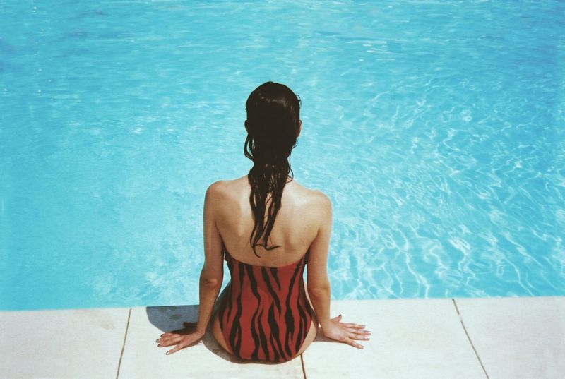 Red print one piece swimsuit at pool — flattering bikini for apple shape style