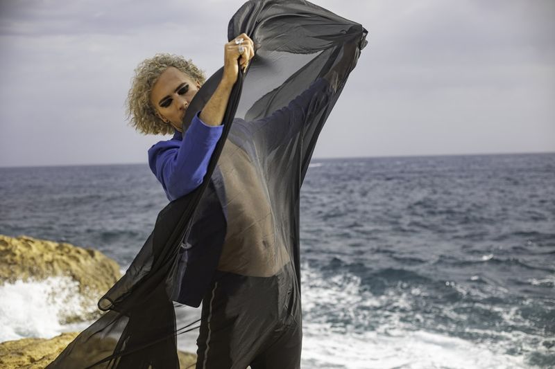 Sheer mesh swim cover up styled over swimsuit at rocky coastline