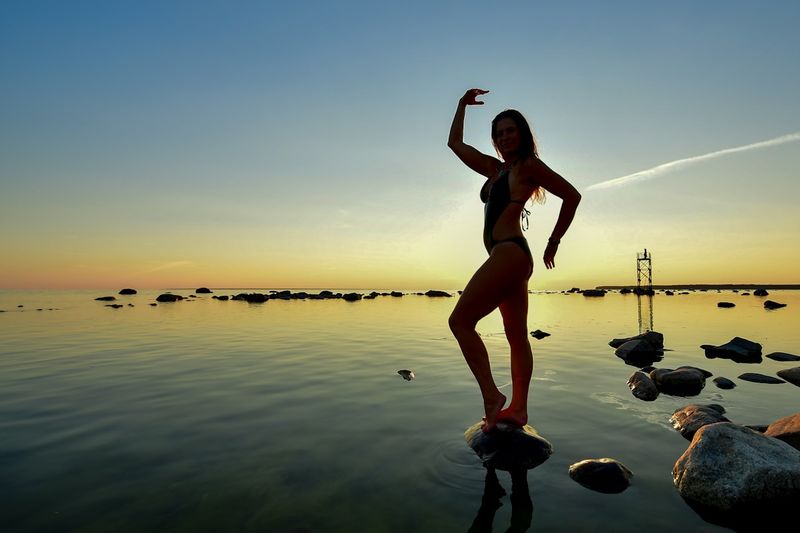 dark color tummy control bikini at sunset silhouette flattering shape
