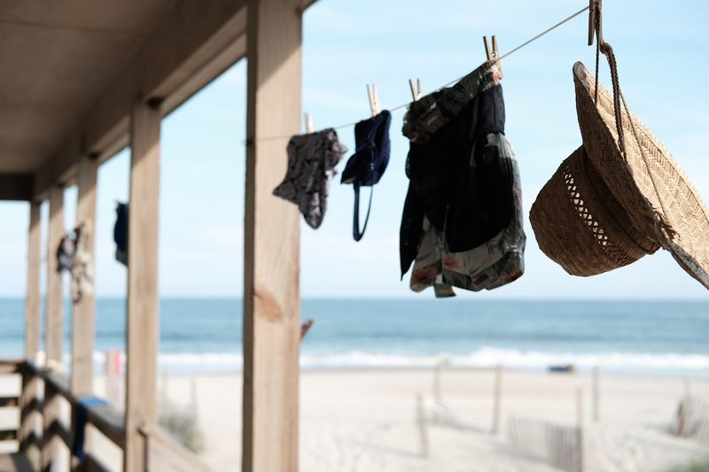 Swimwear care drying on a line at a beach house porch