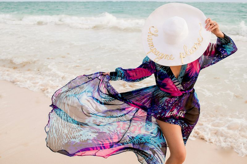 Bikini cover up dress styled with white wide-brim sun hat at beach