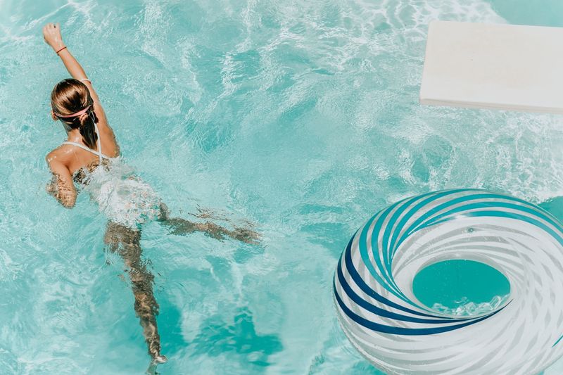 Woman swimming in pool wearing period swimwear bottoms