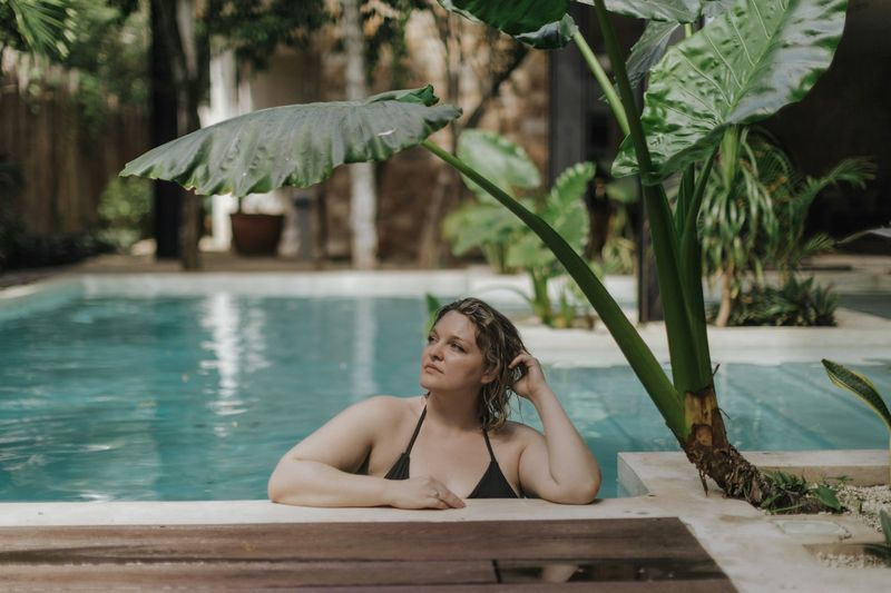 Curvy woman relaxing poolside in a black plus size bikini