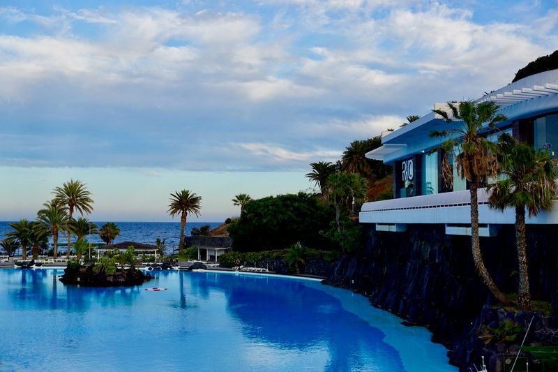 Resort pool and palm trees, a plus size swimwear vacation setting
