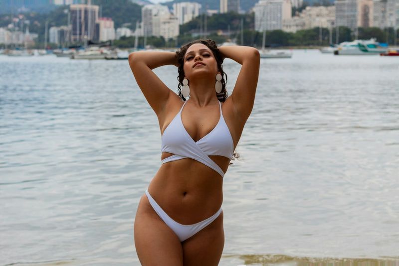 Curvy woman in a white wrap plus size bikini by the water