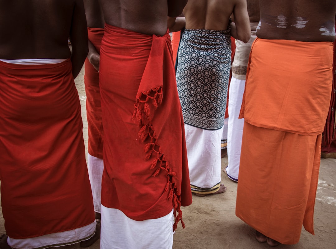Men wearing traditional sarongs and white lower garments.