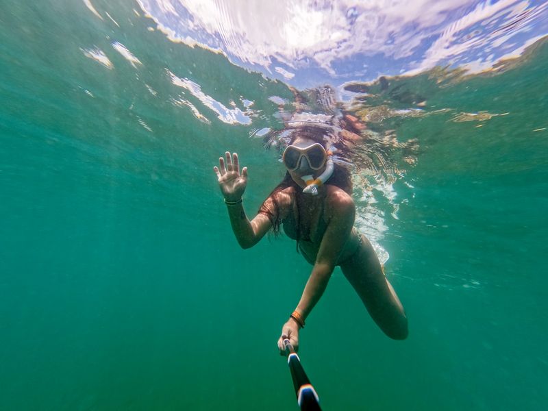 Woman snorkeling in turquoise water in sporty swimwear
