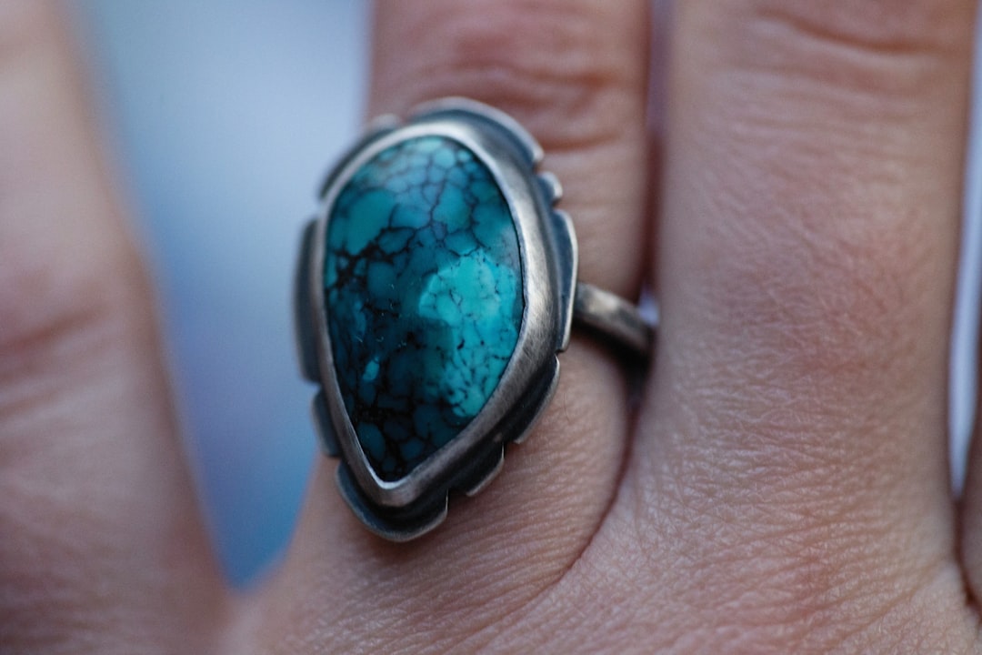 a close up of a person's hand with a ring on it
