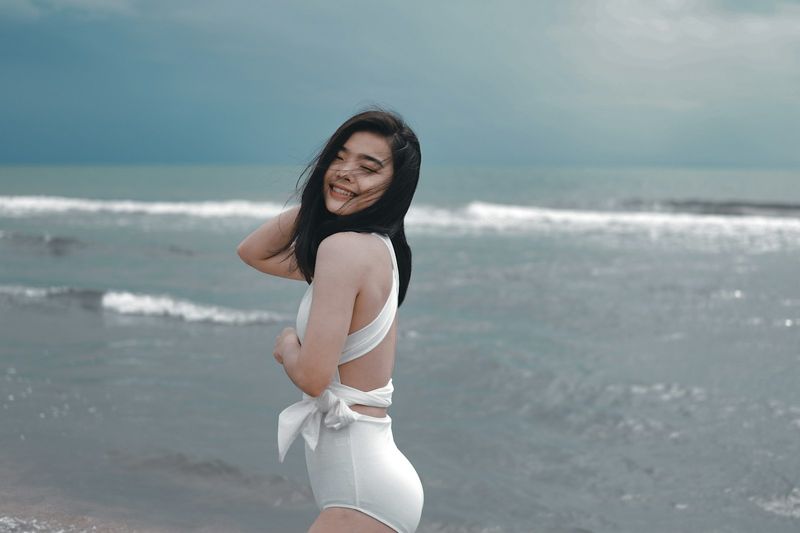Confident white bikini styling on a sunny beach shore