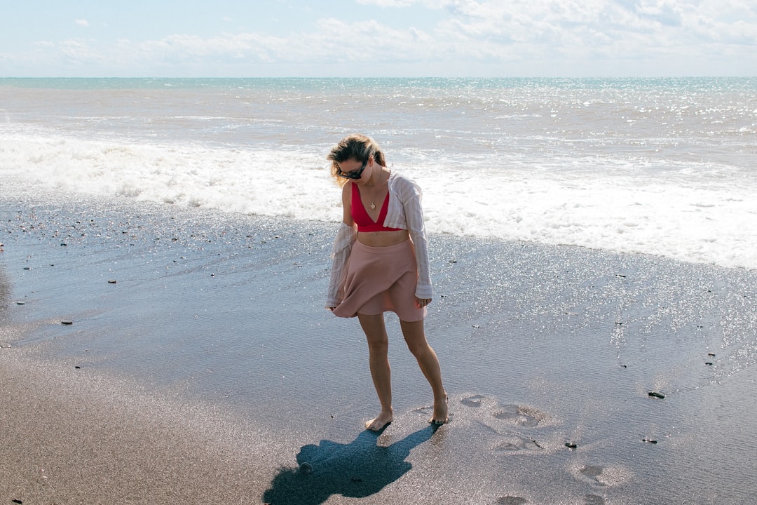 a person in a pink dress on a beach