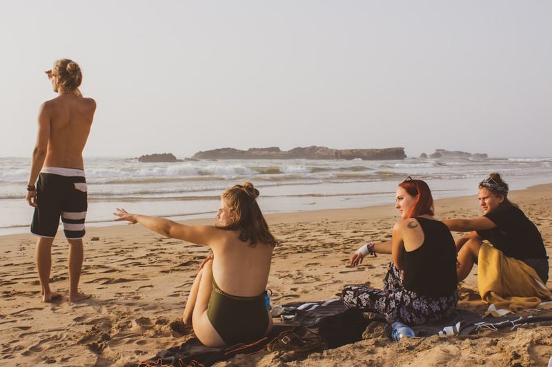 Group of women over 40 enjoying a beach day in bikinis and swimwear