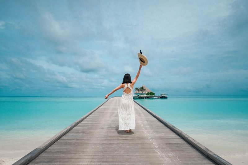 Beach cover-up styled over a black bikini on a jetty