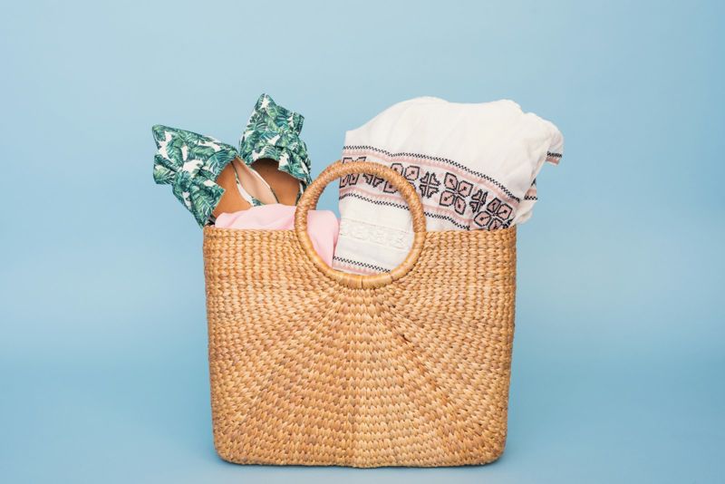 Woven beach bag packed with swimwear and towels, a chafe-free beach kit