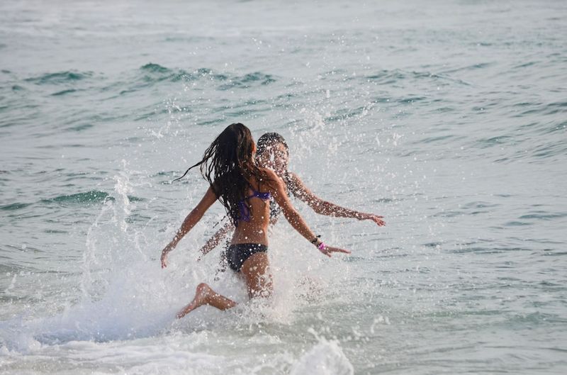 Women in modest swimwear enjoying different water activities