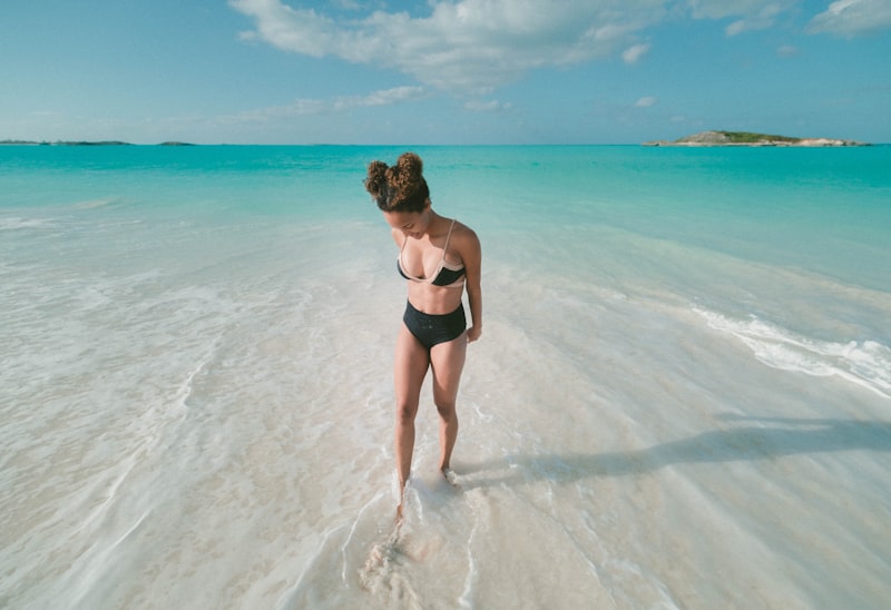 Woman in a bikini on a turquoise beach building a versatile swimwear wardrobe