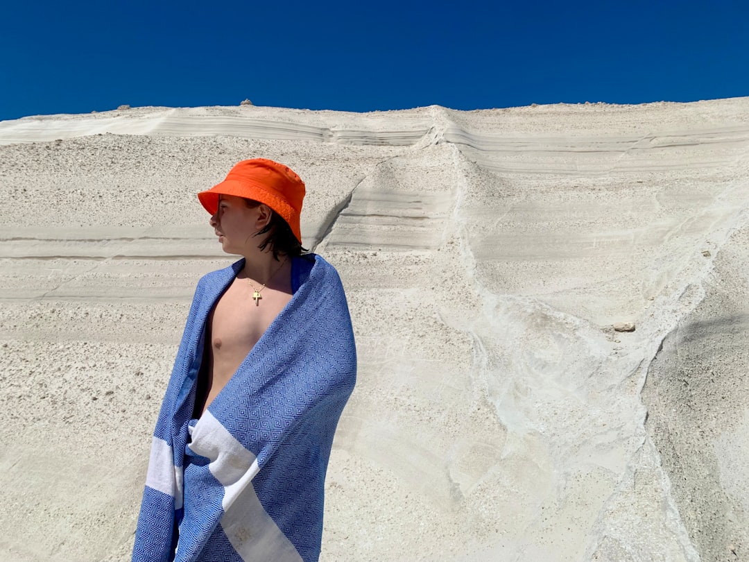 A woman wrapped in a towel standing on a beach
