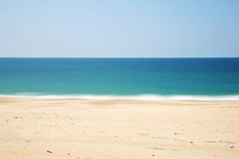 perfect beach day timeline over an empty sandy beach and blue ocean