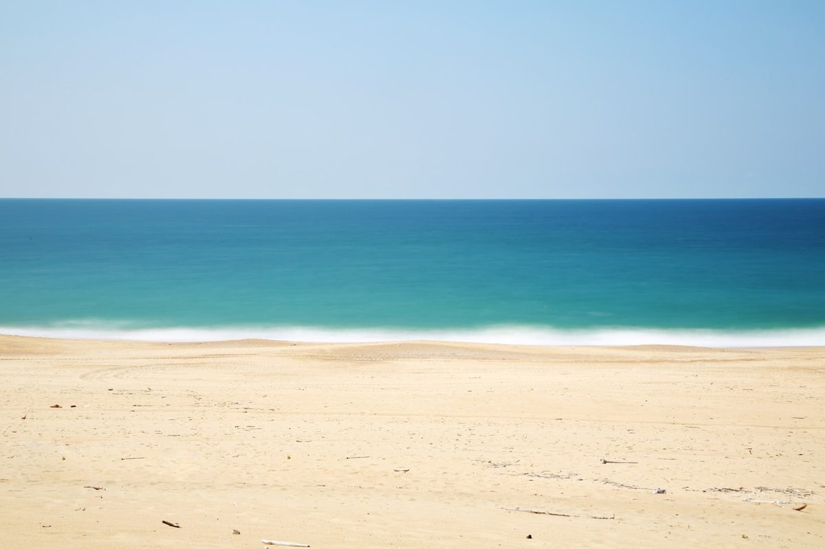 perfect beach day timeline over an empty sandy beach and blue ocean