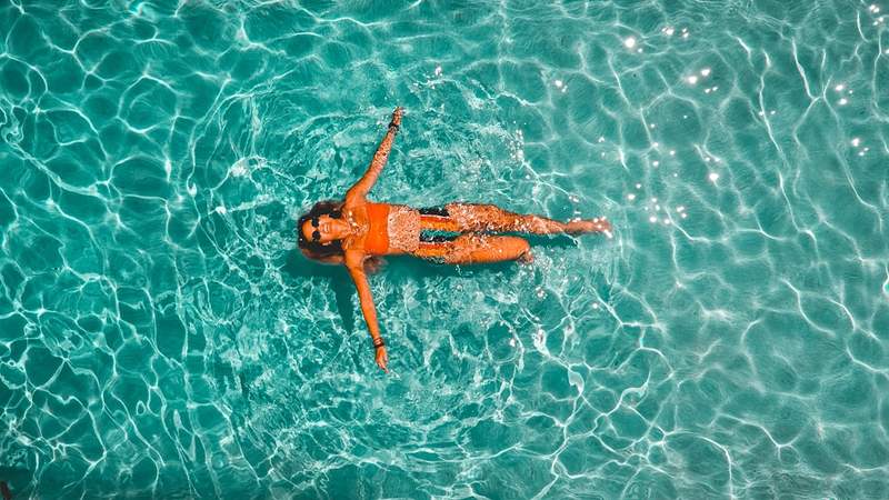 Woman floating in a pool, rinse your swimsuit after chlorine