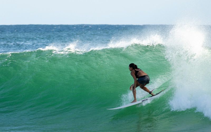 Woman surfing a wave in surf-style swimwear