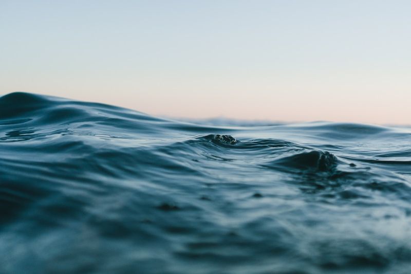 swimming in calm ocean waves at midday on a beach day