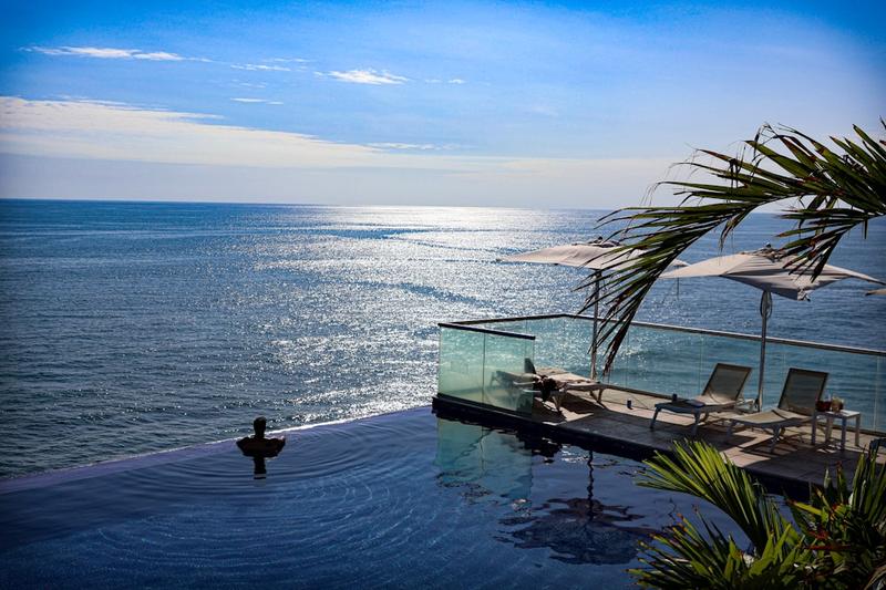 Vacation swimwear at an infinity pool over the ocean