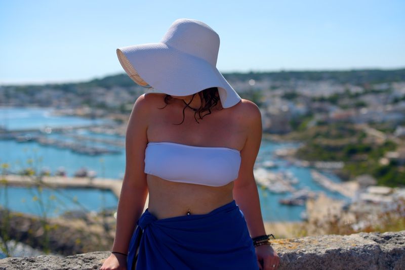White strapless bikini bandeau top styled with a sun hat and sarong