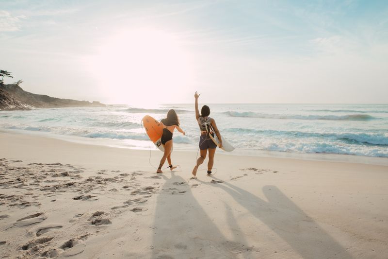 Friends of every age walking to the surf in flattering swimsuits