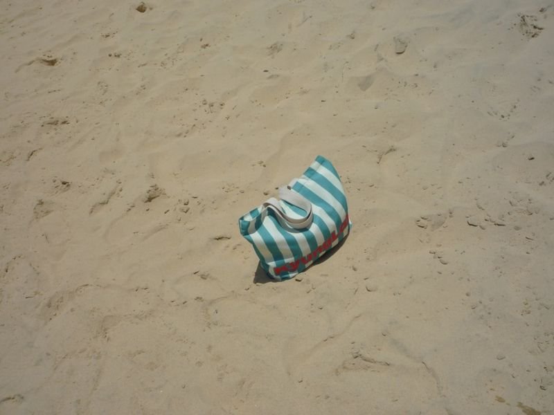 beach bag packing essentials on sand