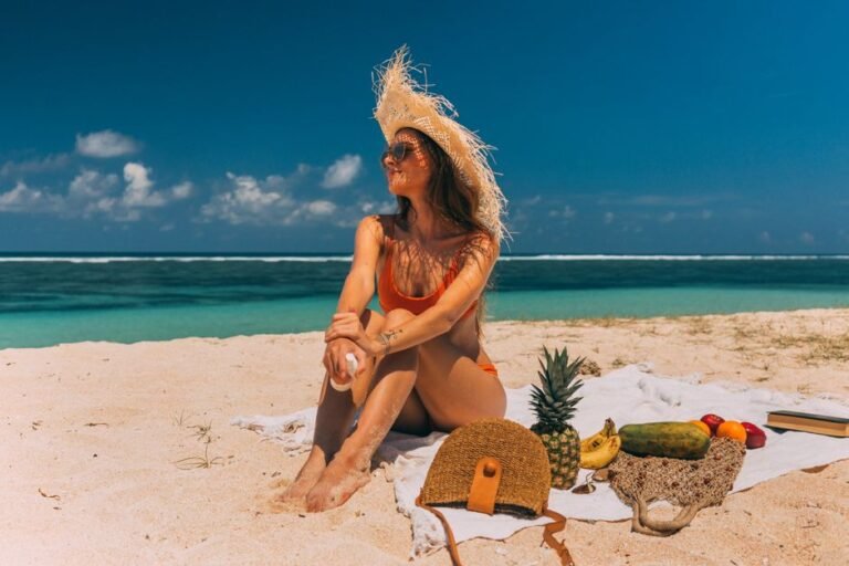A woman relaxing on a sunny beach with tropical fruits and accessories around her.