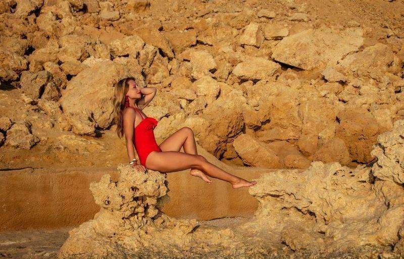 Woman in red swimwear on rocky beach showing swimwear for every body type