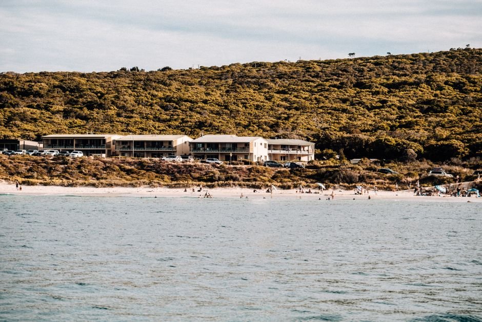 A serene beach with hillside view, perfect for summer vacations.