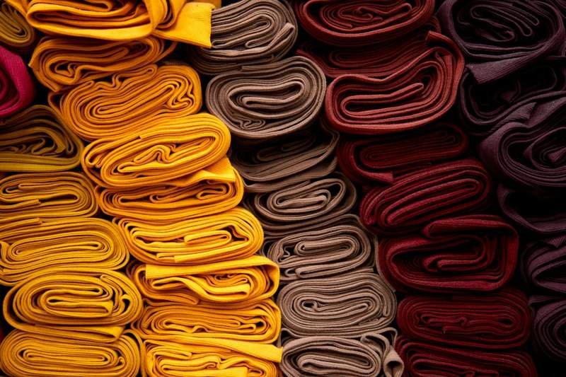 Stack of colorful sarong fabric swatches showing different fabric weaves