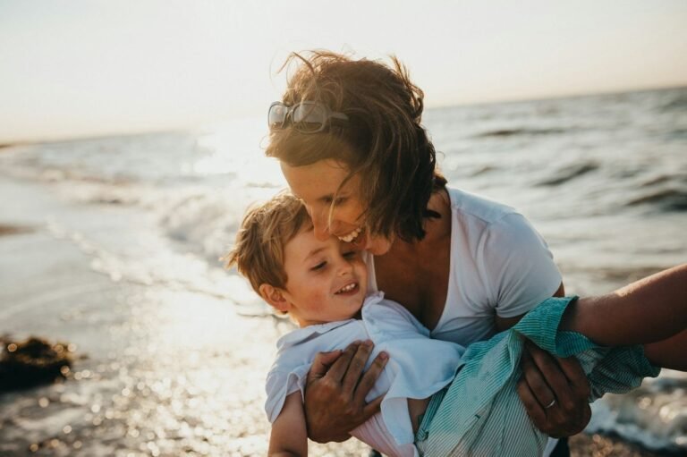 mother holding baby on the beach wearing nursing swimwear