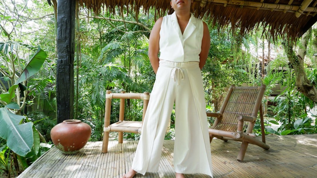 Woman in white outfit standing on a wooden porch